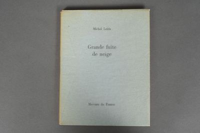 an old book sitting on top of a table next to a black object