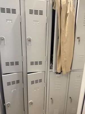 deux casiers dans le couloir d'un immeuble, avec un manteau accroché à la porte