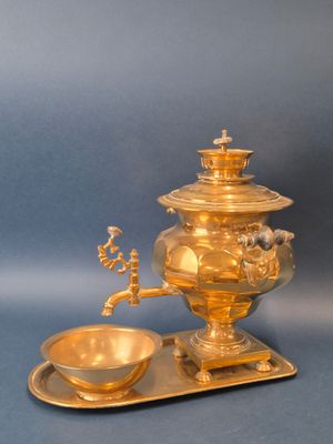 une assiette dorée sur laquelle est posé un bol, sur fond bleu