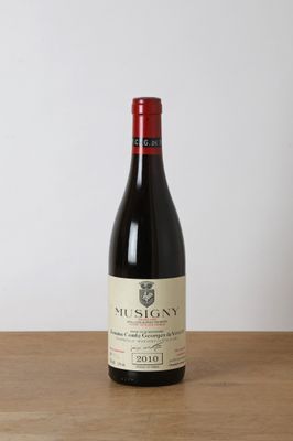 a bottle of red wine sitting on a wooden table