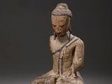 pair of wooden statues of a seated person and a seated person