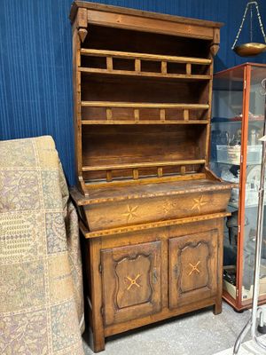 une armoire en bois avec une porte vitrée, devant laquelle se trouve une chaise