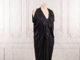 the dress is black and has a large ruffle on it