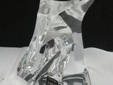 une sculpture en verre transparent représentant un cheval, posée sur une table