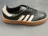 a black and white adidas sneakers with gum soles