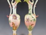 pair of vases with birds and flowers painted on the sides of them