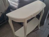 a white table with a shelf on it in a living room