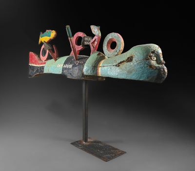 une sculpture représentant un oiseau posée sur un socle métallique, avec un fond noir