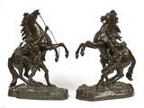 une paire de sculptures en bronze représentant un homme à cheval et une femme à cheval