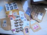une pile de vieux timbres posée sur une table à côté d'un ordinateur portable