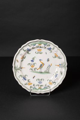 a white plate with a bird and flowers on it