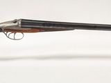 un pistolet avec un canon en bois et un étui transparent posé sur une surface blanche
