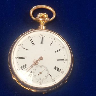 a gold pocket watch with roman numerals on it