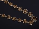 a close up of a gold necklace on a black surface