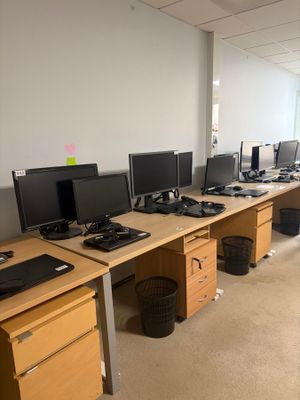 many computer screens on the desks in this office