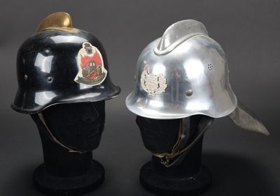 une paire de casques argentés et noirs exposés sur un socle noir