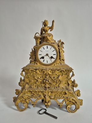 J/ Pendule en bronze doré surmonté d'une jeune pêcheuse.