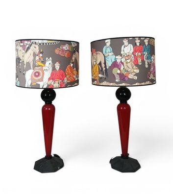 two red lamps with a black base and a red shade on them
