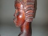 carved wooden head of a woman with a feathered headdress