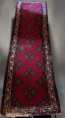 an oriental runner rug on a stand in a room