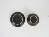 pair of black and gold vases on a white surface