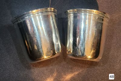 two silver cups sitting on top of a table