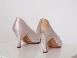 pair of pink and gold high heeled shoes sitting on top of a white table