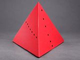 a close up of a piece of red paper with holes in it