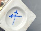 someone is holding a small white object with a blue cross on it