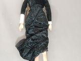an image of a doll with a black dress and gold shoes