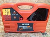 an orange and black portable air compressor sitting on top of a wooden floor