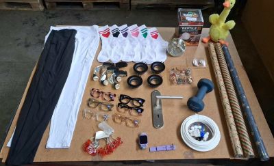 a table with many items on it including glasses, a pair of scissors, a pair of scissors, a pair of glasses, a pair of scissors,