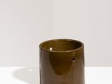 brown ceramic candle holder on a white table with a white background