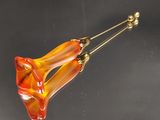 broche en verre en forme de fleur orange et jaune sur un fond noir