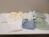 a white table topped with lots of clothes on top of it