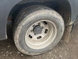 a white van with a flat tire parked on the side of the road