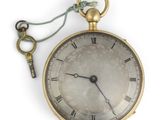 une montre à gousset en or à laquelle est attachée une clé