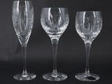three wine glasses are lined up against a black background