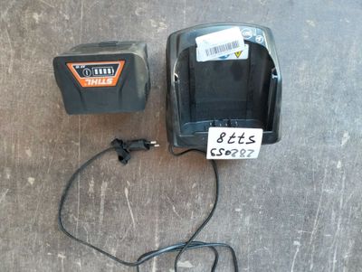 two batteries and a charger sitting on the floor