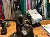 a statue of a woman sitting on a table next to a book