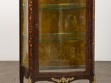 une vitrine ancienne dotée d'une porte en verre et de garnitures dorées