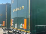 two green semi trucks parked next to each other