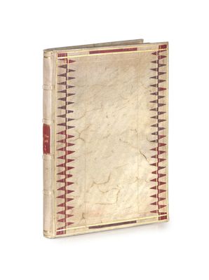 un vieux livre posé sur une table blanche à côté d'un mur blanc