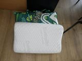 un oreiller blanc posé par terre à côté d'une chaise noire