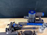 un aspirateur bleu et noir posé sur une table en bois