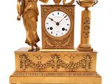 une horloge en or surmontée d'une statue