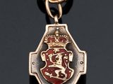 a close up of a red and gold medal on a black surface