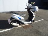 a scooter parked in a parking lot with a bag on the back