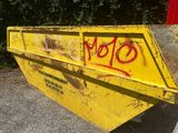 une benne jaune avec des graffitis sur le côté
