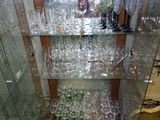 many wine glasses on the glass shelves in the room
